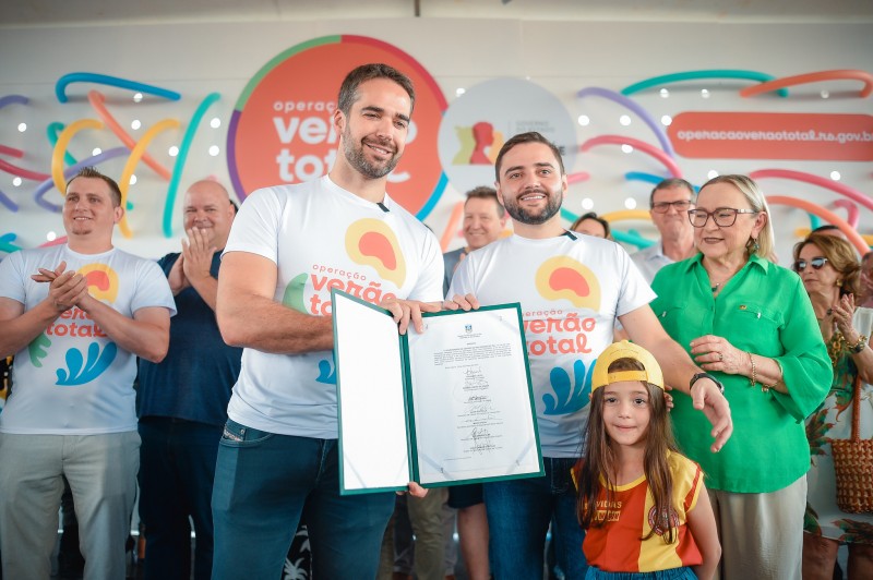 pessoas posam para foto segurando decreto assinado