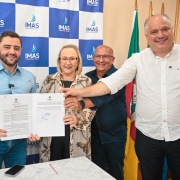Foto mostra vice-governador Gabriel Souza, em ato de assinatura, com autoridades do Estado e munic&iacute;pio de Tramanda&iacute;