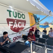 Foto mostra unidade do Tudo F&aacute;cil m&oacute;vel e pessoas aguardando atendimento